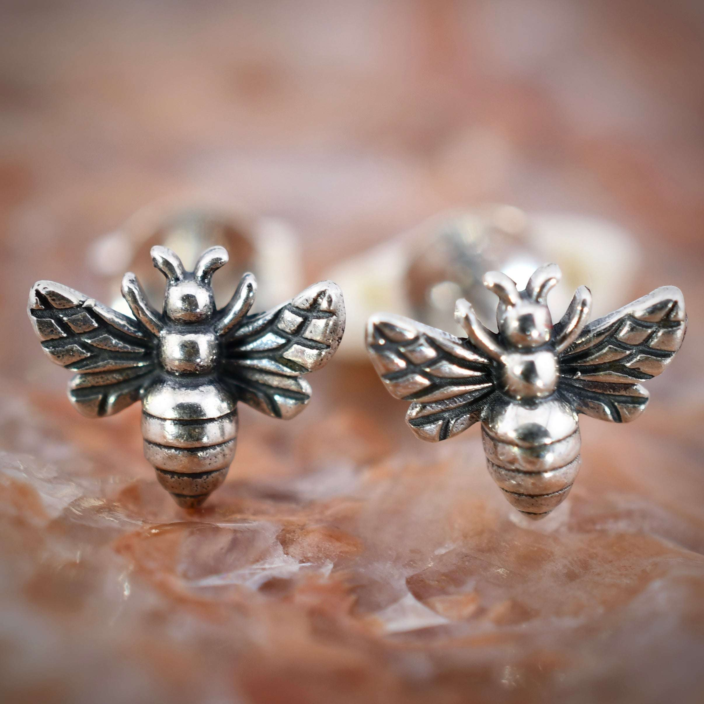 Recycled sterling silver tiny bee post earrings with detailed wings and segmented body.